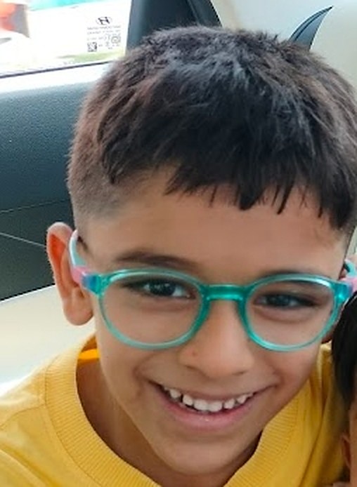 Aveer grinning in his teal glasses